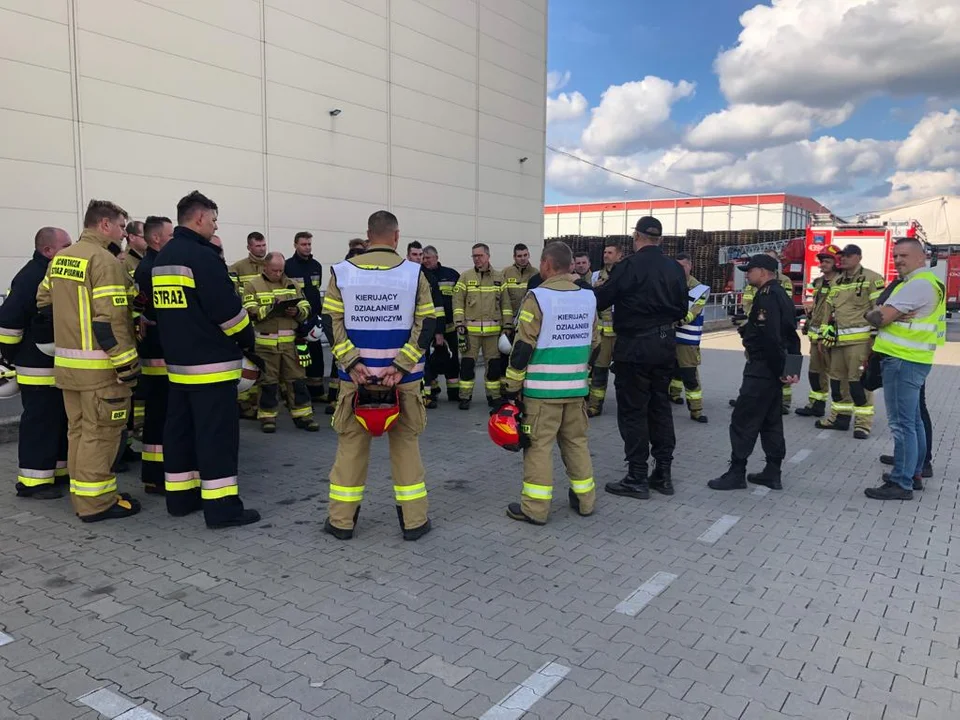 Współpraca jednostki policji i straży pożarnej przy gaszeniu pożaru na terenie zakładu pracy w Gostyniu