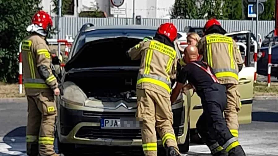 W centrum Jarocina, na parkingu marketu zapalił się samochód - Zdjęcie główne