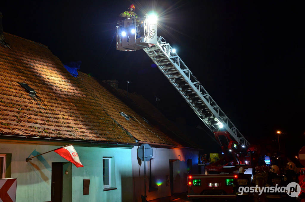 Strażacy okrywają plandeką zniszczony dach w Borku